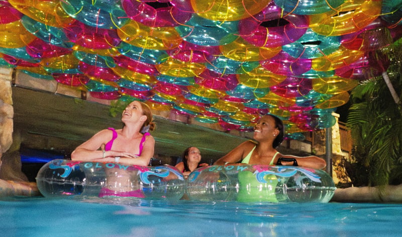 People in a lazy river with colorful inner tubes above 