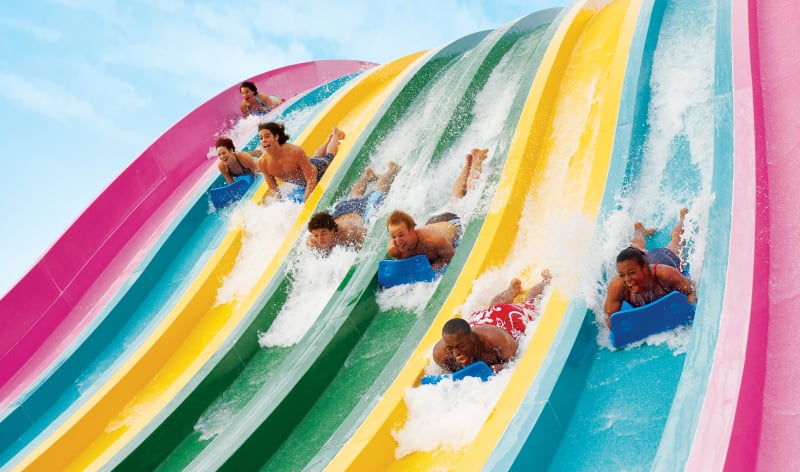 People going down a mat water slide