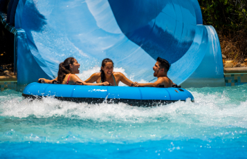 Three people in a large waterslide tube