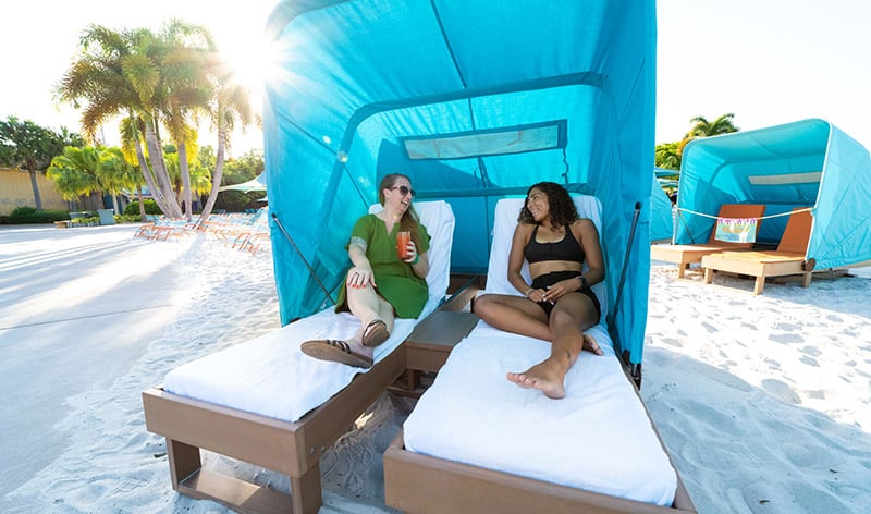 Guests relaxing on a day bed at Aquatica Orlando